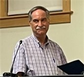 Dr. Robert Duncanson standing at a podium smiling