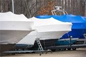 Boats in storage covered in white and blue shrink wrap