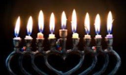 Eight lit candles in a metal candle holder