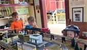 Kids watching model trains running on a track
