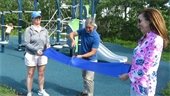 Select Board Member Cory Metters cutting a blue ribbon held by Deputy Director of Community Services Aimee Howell and Town Manager Jill Goldsmith