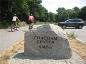 Stone marker next to a bike path with cyclists