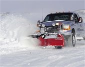 Silver pick-up truck plowing snow