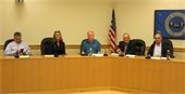 Select Board and Town Manager seated at the dais in the large meeting room