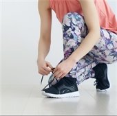 Woman tying her sneaker indoors