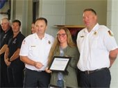 Naomi Norcross flanked by Fire Chief Justin Tavano and Deputy Fire Chief Ryan Clarke
