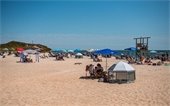 People with chairs and umbrellas on a beach