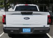 Rear view of a white F150 Ford Pick-up with a Chatham EV decal