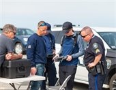 Police Officers and Fire Fighters looking at radio control device in a parking lot