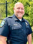 Man in Police uniform standing outdoors smiling