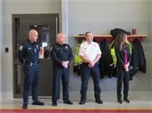 Two men in Police uniforms standing next to a firefighter and a woman in a blue suit