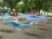 Painted and decorated whale and shark shapes mounter on poles in a park