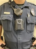 Police officer in blue uniform wearing a body worn camera