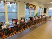 Ten pots of chili lined up on a tables