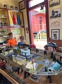 Three young children watching model trains running