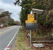 An LED panel mounted below a 30 mile per hour speed advisory sign beside a roadway