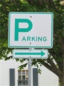 White sign with green lettering for Parking