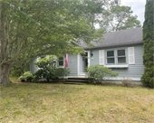 Small ranch home with American flag and open front door